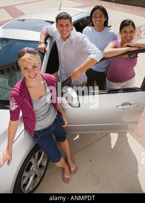 Multi-ethnic friends leaning on car Stock Photo
