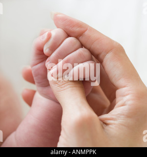 Close up of mother holding baby’s hand Stock Photo