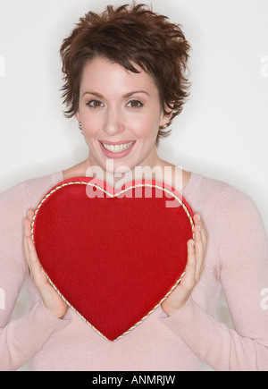 Woman holding heart-shaped box Stock Photo