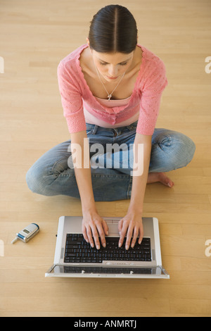 Young woman typing on laptop Stock Photo
