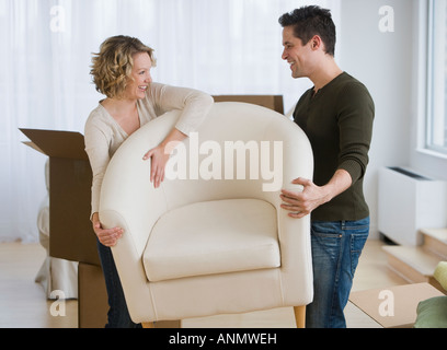 Couple carrying armchair Stock Photo