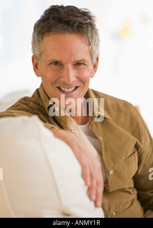 Man sitting on sofa Stock Photo