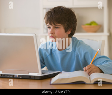 Boy doing homework with laptop Stock Photo