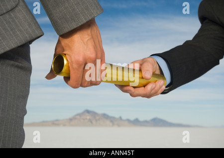 Businesspeople handing off baton in relay race, Salt Flats, Utah, United States Stock Photo