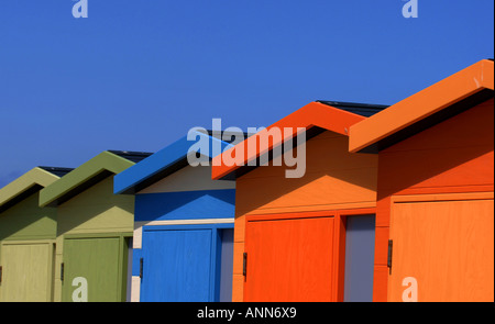Modern beach huts on Sussex coast bathed in morning sunshine set against blue summer sky. Picture by Jim Holden. Stock Photo