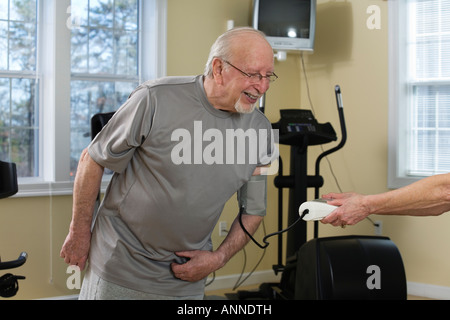 Wife checking blood pressure of her husband in the gym. Stock Photo