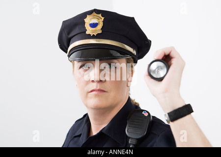 Portrait of a Police woman holding a flashlight. Stock Photo