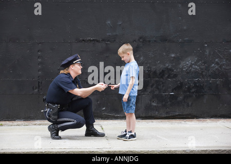 Woman police officer talking to a boy. Stock Photo