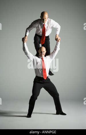 Two male acrobats in business suits performing Stock Photo