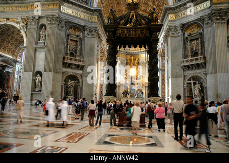 Within Rome's St Peter's basilica Bernini's colossal baldachin or canopy above the papal altar dominates the long nave Stock Photo