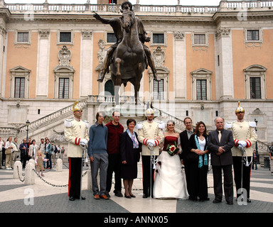 A Presidential Guardsman, his bride escort and family, pose for wedding photos in Rome's Michelangelo-designed Capitoline piazza Stock Photo