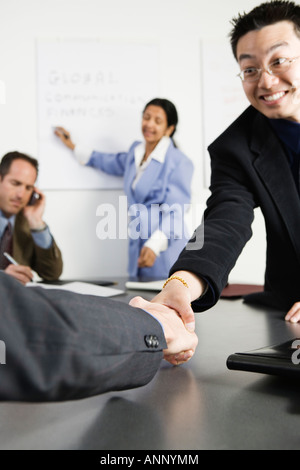 View of businessmen shaking hands in an office. Stock Photo