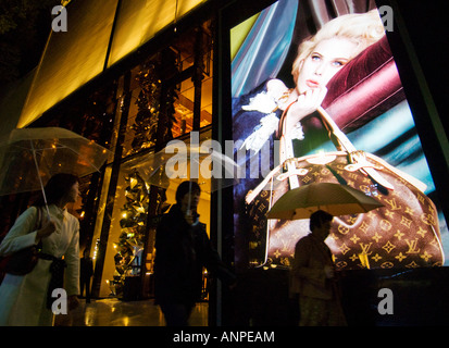 Night view of illuminated billboard in window of Louis Vuitton store in Omotesando Tokyo Japan