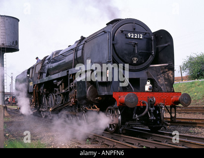 Historical British Rail engine Class 9F 92212 built 1959 working at Great Central Railway water filling tower Loughborough Leicestershire England UK Stock Photo