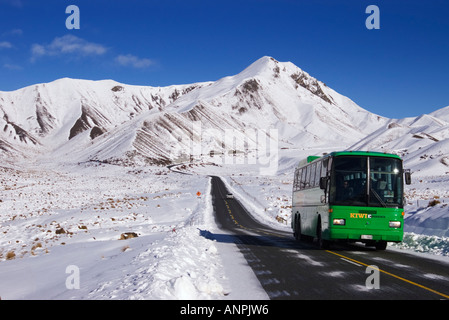 Tourist bus travelling through Lindis Pass, New Zealand in winter Stock Photo