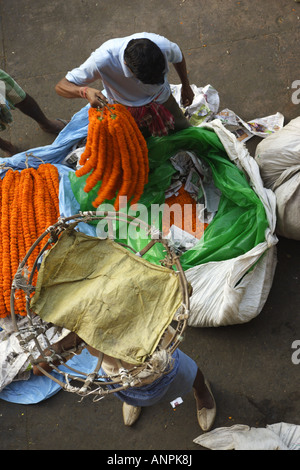 Men work at the Mullick Ghat Flower Market neat the Howrah Bridge in Kolkata, India. Stock Photo