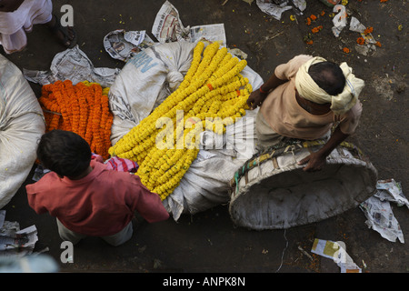 Men work at the Mullick Ghat Flower Market neat the Howrah Bridge in Kolkata, India. Stock Photo