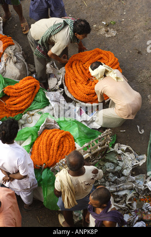 Men work at the Mullick Ghat Flower Market neat the Howrah Bridge in Kolkata, India. Stock Photo