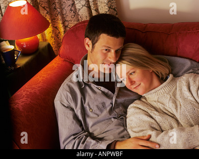 Affectionate young couple together on sofa at home Stock Photo