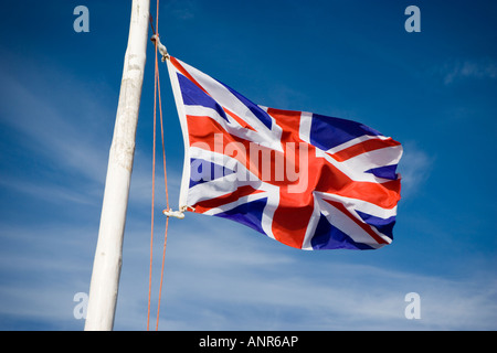 Union Jack British flag flying on a weathered flag pole Stock Photo
