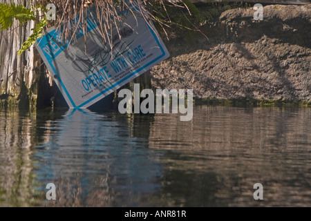 Manatee Boating Safety Sign Partially Covered with Brush Stock Photo