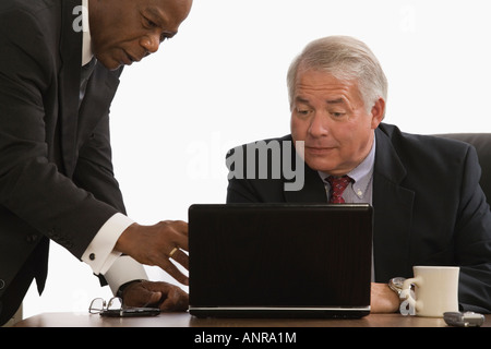 Two businessmen looking at a laptop in an office Stock Photo