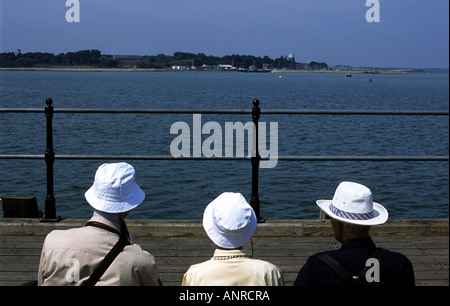 Visitors take in the views towards Shotley Gate in Suffolk from Harwich pier in Essex, UK. Stock Photo