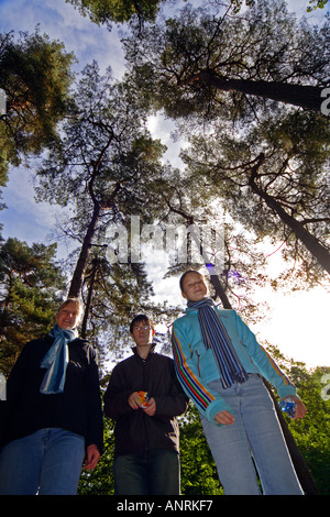 Upward wide angle shot with room for copy of a family of three people with a canopy of trees above them Stock Photo