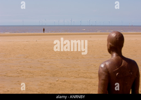 Another Place by Antony Gormley Iron man statue on Crosby Beach with Burbo Bank offshore wind farm in the distance. Merseyside, UK Stock Photo