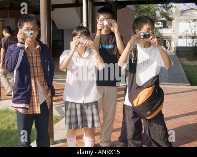 Asian High School Students In Uniform Taking Photos With Digital Cameras Taiwan China Stock Photo
