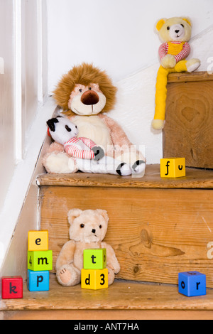 Soft toys and alphabet blocks on staircase Stock Photo