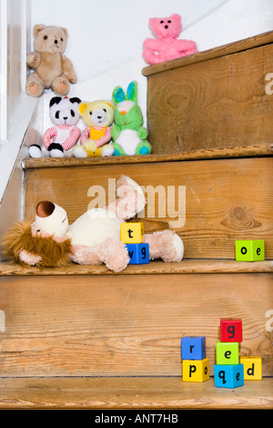 Cuddly toys and alphabet blocks on staircase Stock Photo