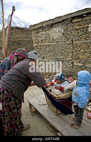 Family taking care of the baby. Ngawal village. Annapurna circuit trek. Nepal Stock Photo