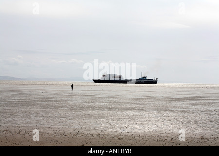 Ferry sailing past  Another Place figure sculptures on the beach by Anthony Gormley at Crosby Liverpool England Stock Photo