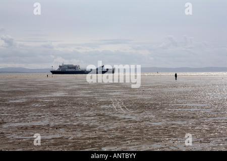 Ferry sailing past  Another Place figure sculptures on the beach by Anthony Gormley at Crosby Liverpool England Stock Photo