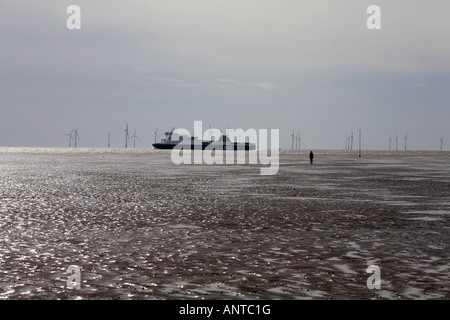 Ferry sailing past  Another Place figure sculptures on the beach by Anthony Gormley at Crosby Liverpool England Stock Photo
