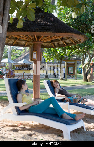 Two young women sitting on deck chairs Stock Photo