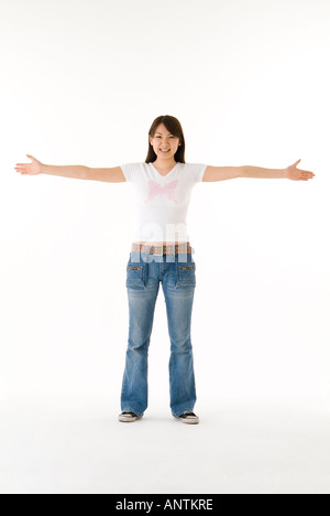 Young woman standing with arms outstretched Stock Photo