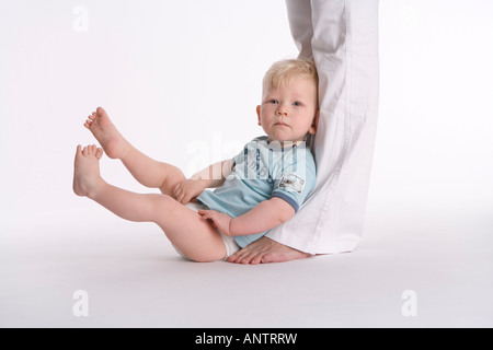 Little boy sitting against his parents legs Stock Photo