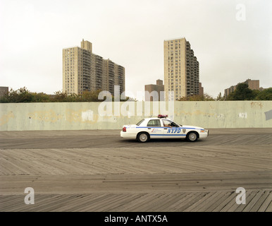 Police car in service during patrol activity along the pathway in front of the sea side at Coney Island beach area New York Us Stock Photo