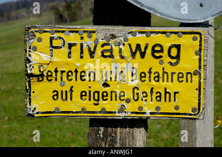 Yellow sign privat way trespassing on your own risk Stock Photo