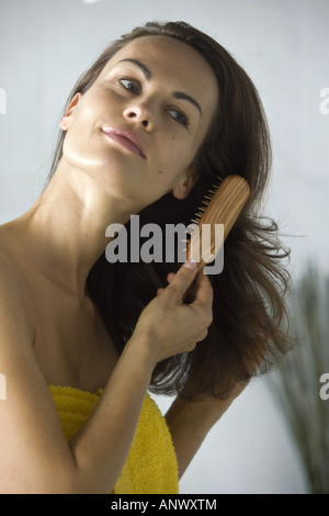 young woman combing her hair Stock Photo