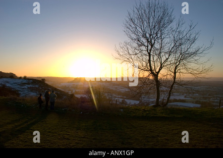 Winter scene with sun setting behind leafless trees overlooking Vale of Gloucester from Frocester hill on Cotswolds Stock Photo