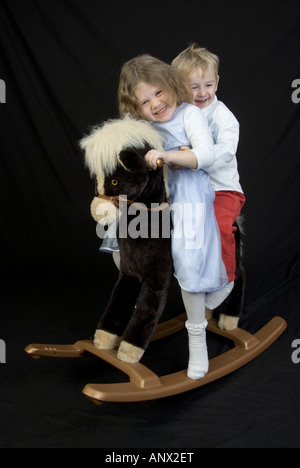 kids on a rocking horse Stock Photo