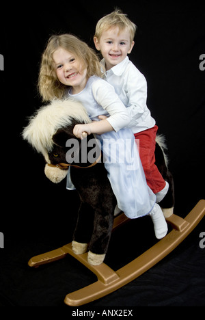 kids on a rocking horse Stock Photo