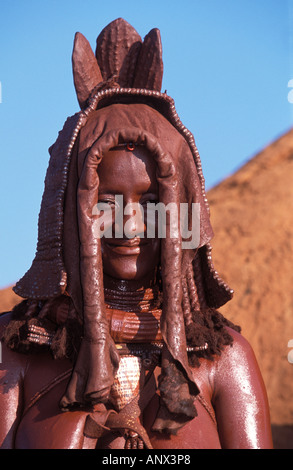 A Himba woman, with red clay spread on her body, wearing a traditional head dress, in Namibia, Africa (MR) Stock Photo