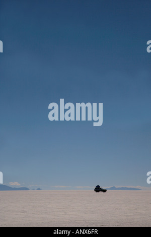 car driving across salt flats, Uyuni, Bolivia Stock Photo