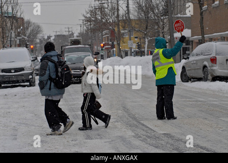 School children crossing a street during a snow storm Montreal Canada Stock Photo