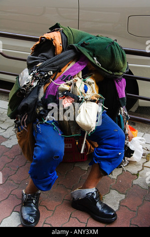 Japan, Honshu Island, Tokyo, Ginza District. Homeless tramp slumped in street. Stock Photo