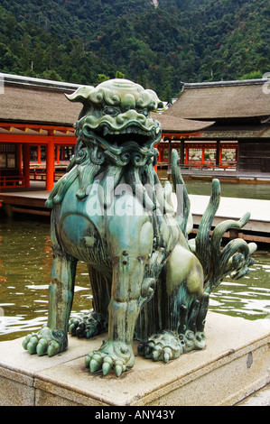 Japan, Honshu Island, Hiroshima Prefecture, Miyajima Island, Itsukushima Shrine. Guardian lion statue at high tide. Stock Photo